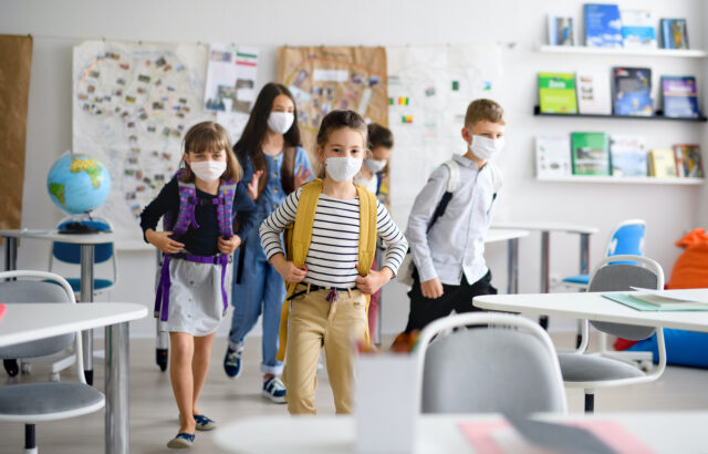 Group of children with face mask back at school after covid-19 quarantine and lockdown.