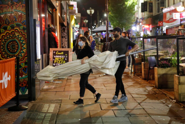 Staff removes an umbrella at a bar the night before a local lockdown amidst the spread of the coronavirus disease (COVID-19) in Liverpool