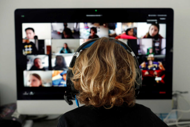A student takes classes online with his companions using the Zoom APP at home