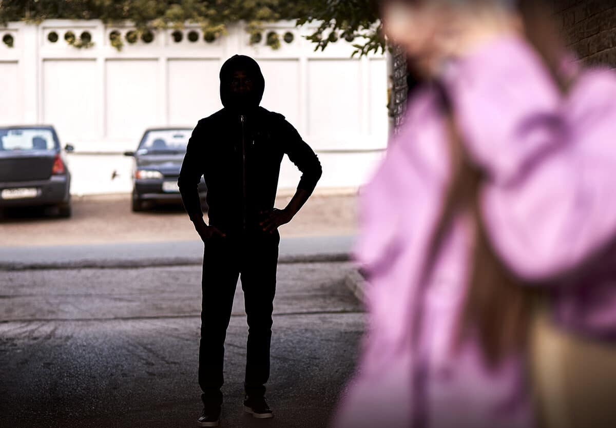 a person in a hoodie standing on the street